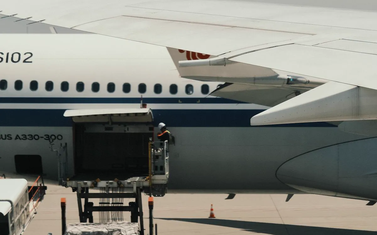Cargador de plataforma ubicado en la puerta de carga abierta de un Airbus A330 en la rampa